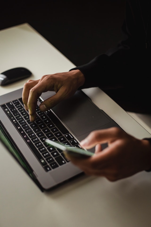 Someone typing on the keyboard of a laptop