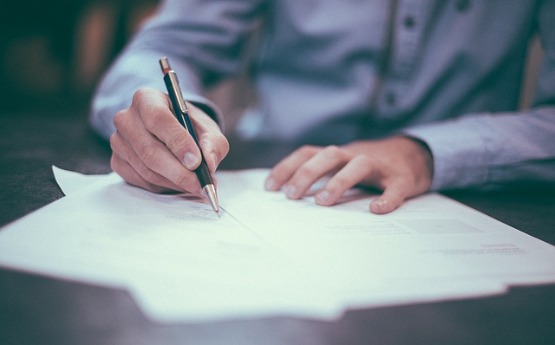 person writing at desk