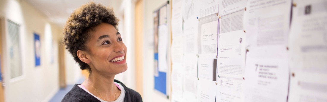 student looking at information board