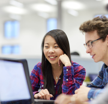 students consulting with laptop