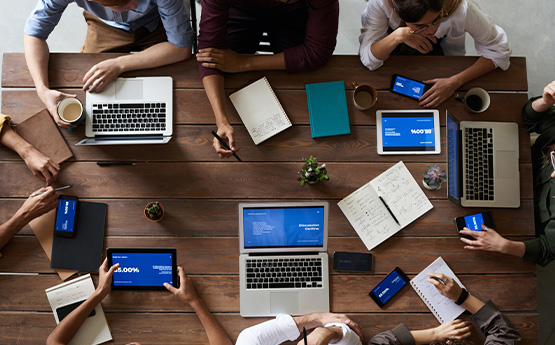 a group of people having a meeting with their devices