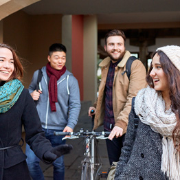 Happy students walking underneath an archway