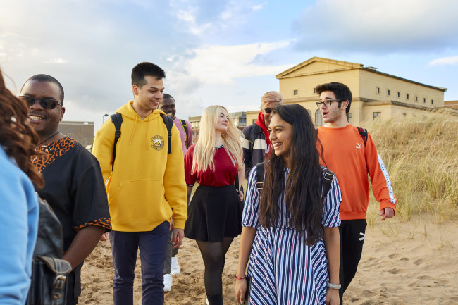 Students walking on the beach on Bay Campus