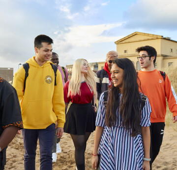 Students walking near sand