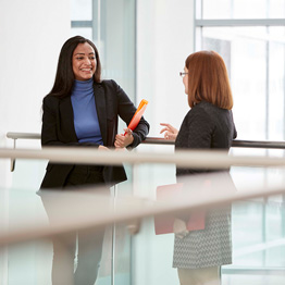 Two businesswomen talking on a balcony