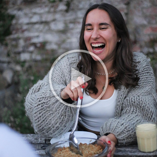 Business owner laughing with food on table 