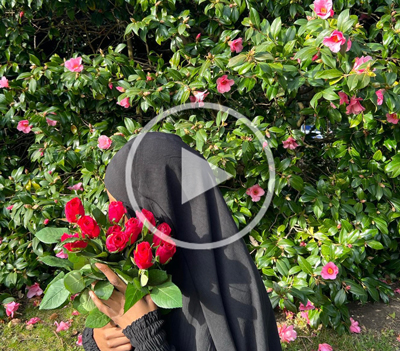 business owner with flowers in front of face