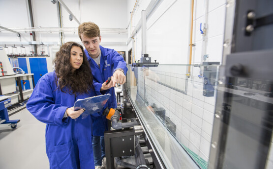 students in lab pointing at object