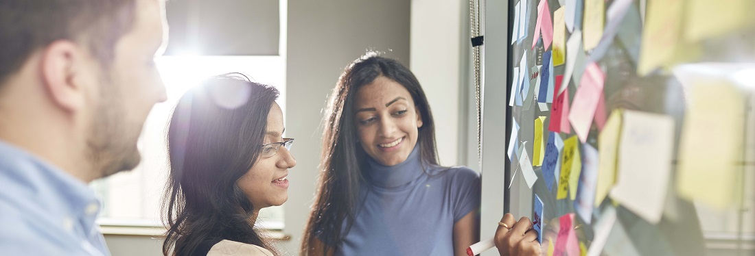 Three students looking at a board