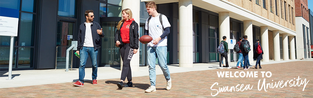 Two groups of students walking across campus