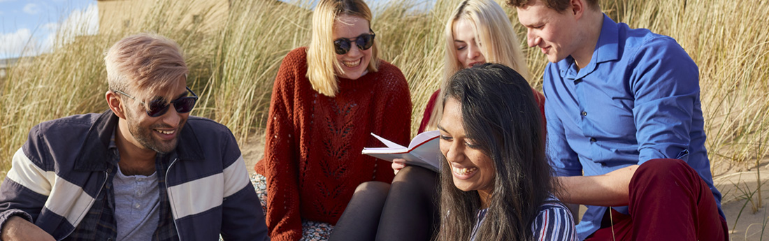 Three smiling students walking in front of Singleton Abbey