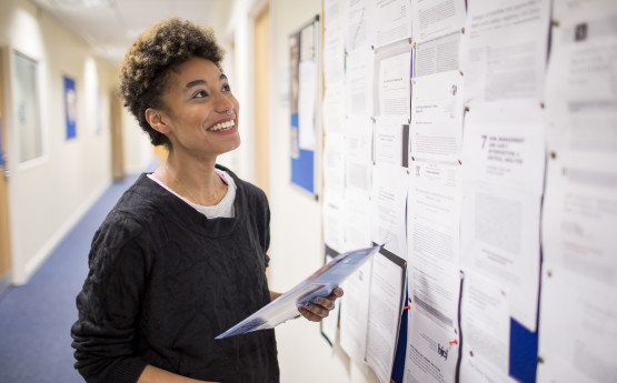 Female student looking at notice board