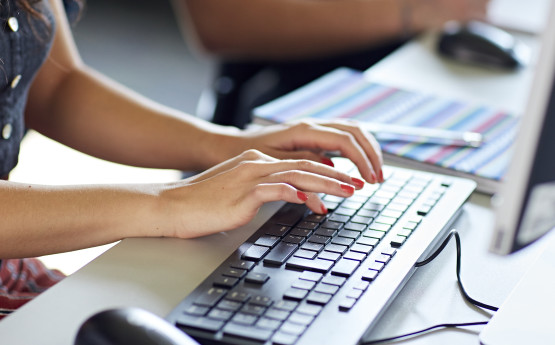 student typing on a keyboard