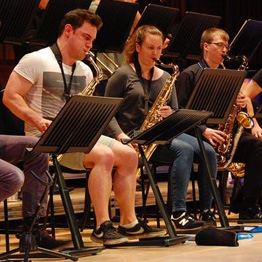 Three people playing brass instruments