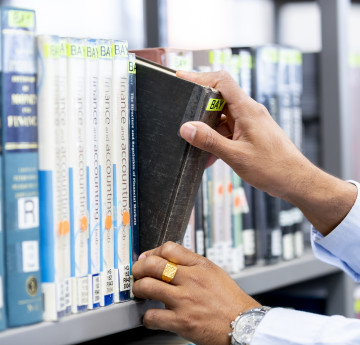 Hands selecting a library book