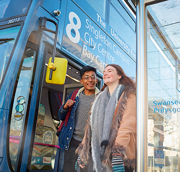 Two students stepping off a University service bus 