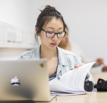 A student learning with open laptop and notebook