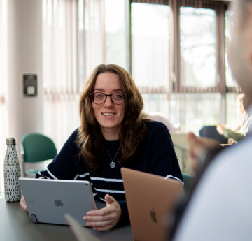 Image of simling student in front of laptop