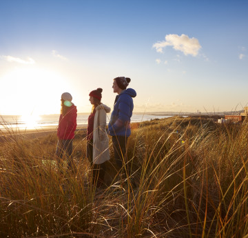 Three students standing in the dune