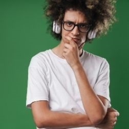 Man with curly hair against a green background